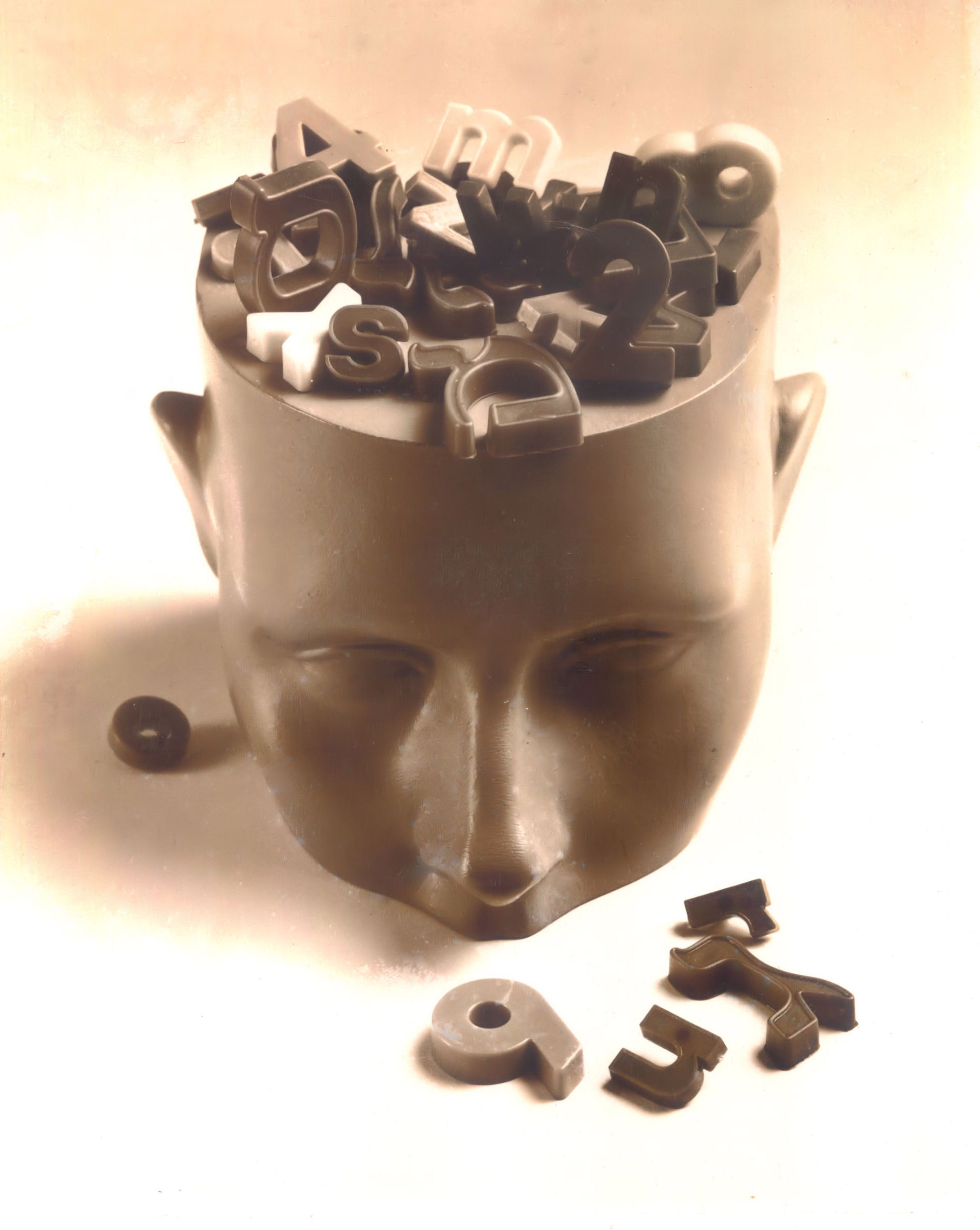Sculpted head with letters spilling out — Dr. Guedalia's signature visual for language, reading, and executive-function work
